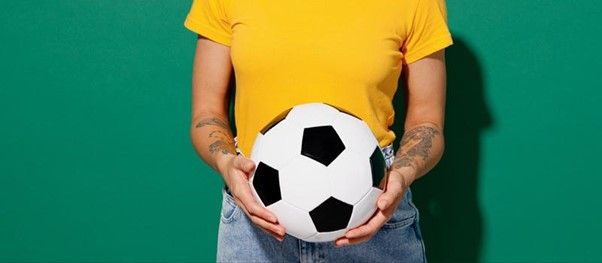 Close em mãos segurando bola de futebol